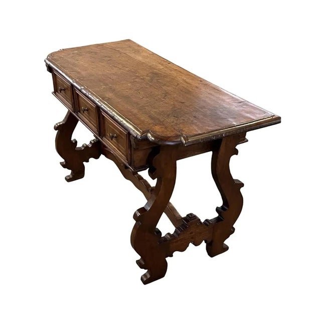 Console table hand-made in Italy in the mid 1700s using walnut. The top is made of a single board with ogee edges and...