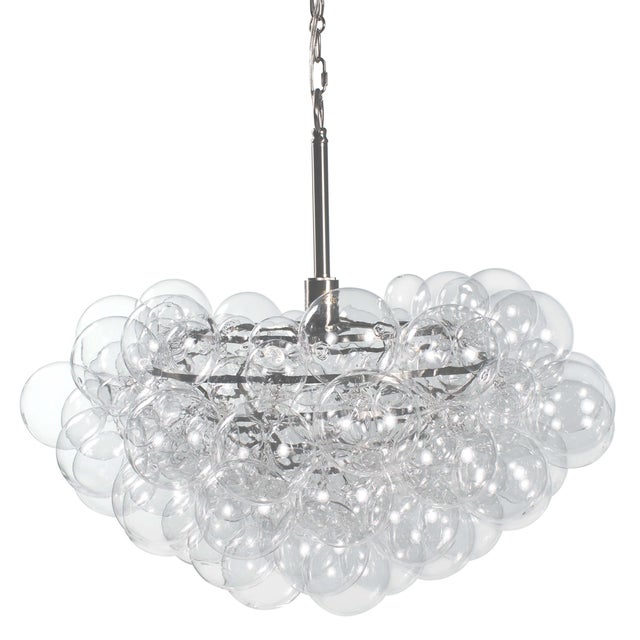 Light and airy, the Bubbles chandelier radiates light through a cluster of hand blown glass globes. The tiered metal frame...