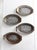 This vintage set of four aluminum sizzler plates features a charming leaf motif and comes with protective wooden chargers....