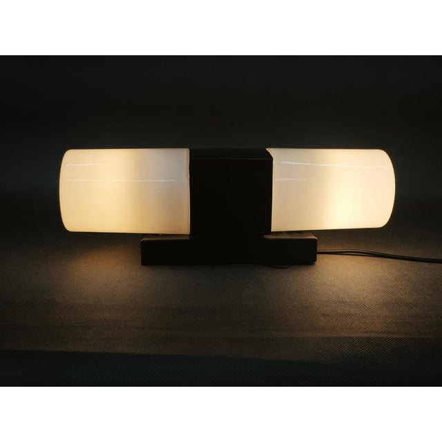 A distinctive pair of czechoslovak mid-century modern wall lights from the 1960s, executed in white opaline glass and...