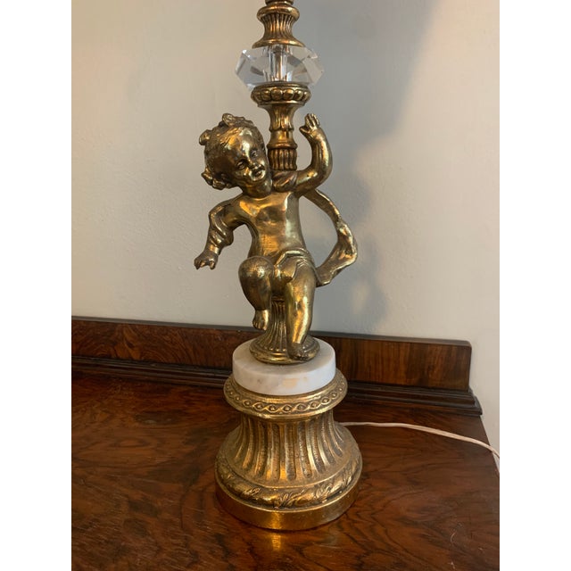 A beautiful table lamp and decorative piece. Made with french gilt, glass and marble details, and blue glass for a subtle...