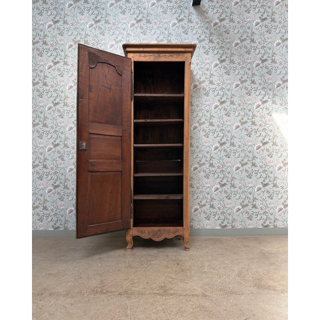 An elegant antique bonnetière dating from the late 19th century, crafted from solid cherry wood. Its slender silhouette...