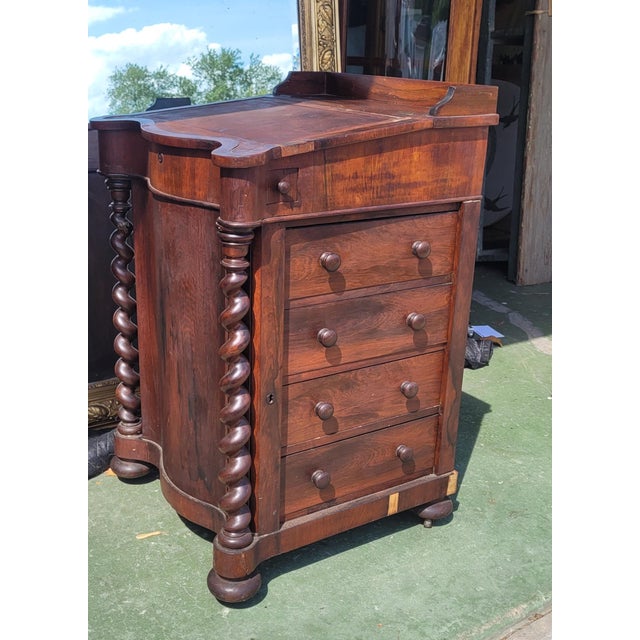 Victorian-era rosewood veneer Davenport desk featuring distinct barley twist columns on the front corners. Davenport desks...