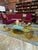 Exceptional vintage sculptural coffee table featuring a thick square glass top supported by four dramatic stepped brass...
