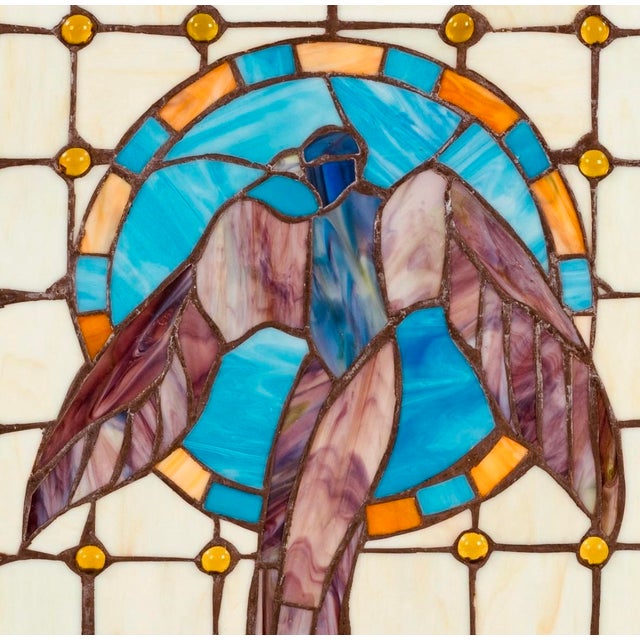 Exquisite antique stained glass panel with hanging hardware. This piece features beautiful colors and a rising bird amidst...