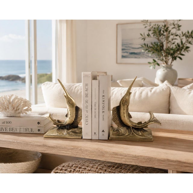 A striking pair of vintage brass finish swordfish bookends featuring detailed wave bases and elegant upward leaping forms....