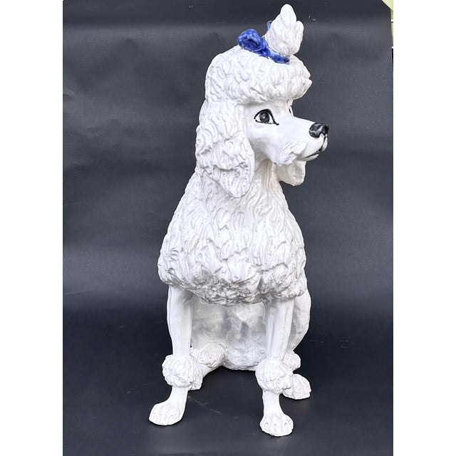 A charming Italian faience poodle figure, standing 21 ¾ inches tall and modeled in a seated pose with expressive, alert...