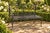 A striking vintage Regency-style garden bench crafted from painted iron with elegant reeded strapwork. The open back...