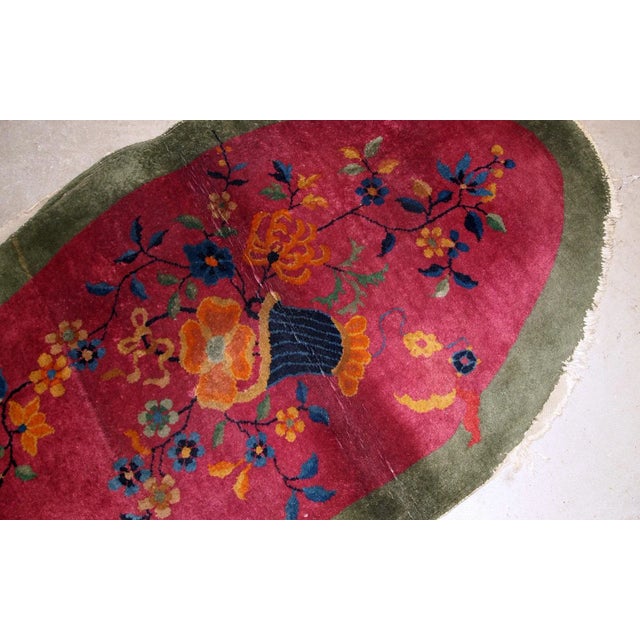 Handmade antique oval decorative rug from China in original good condition. The rug is in fuchsia and green shades....