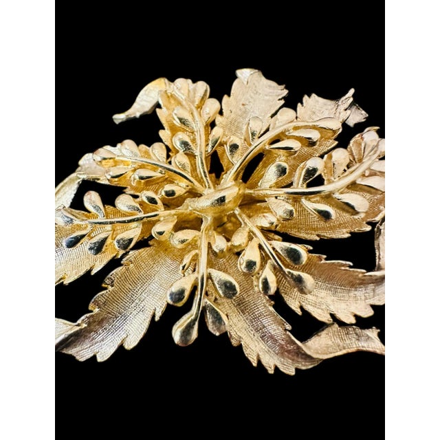 Vintage Large Floral Brooch A center of symmetrical leaflets layer on a base of curling textured leaves. A quality work of...