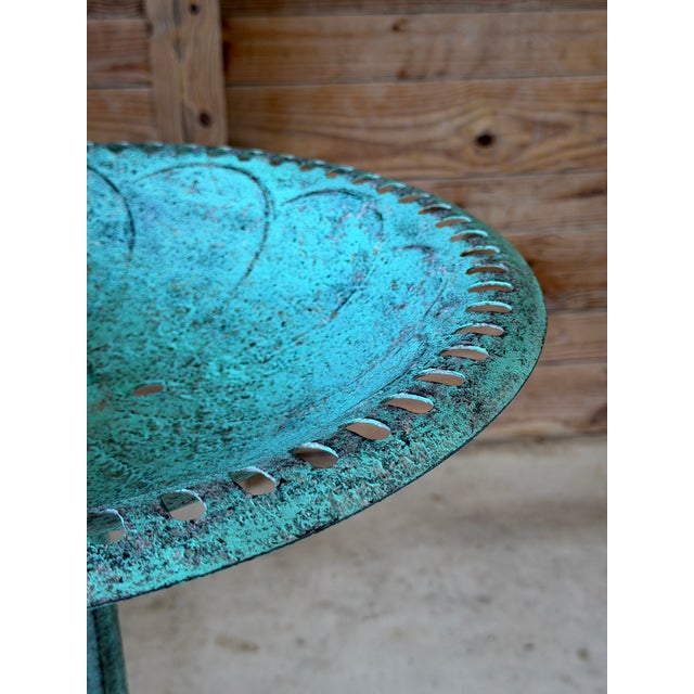 An elegant vintage cast iron garden tazza featuring a beautifully weathered verdigris finish and an ornate scrolling...