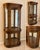An elegant vintage illuminated curio cabinet featuring graceful curved glass panels, richly figured walnut veneers, and a...