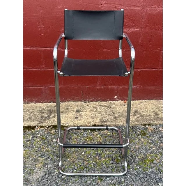 This striking Mid-Century Modern bar stool features a sleek cantilever design with a polished chrome tubular steel frame....