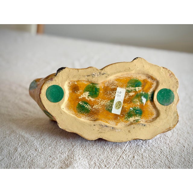 A charming vintage yellowware pig figurine, likely American, dating to the mid-20th century. This piece features a warm...