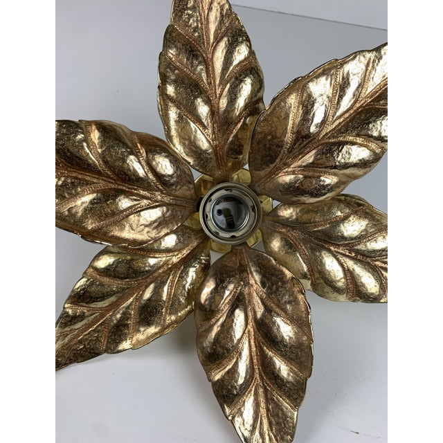 A brass floral florentine wall sconce attributed often to willy daro for massive lighting, belgium 1970s. This iconic wall...