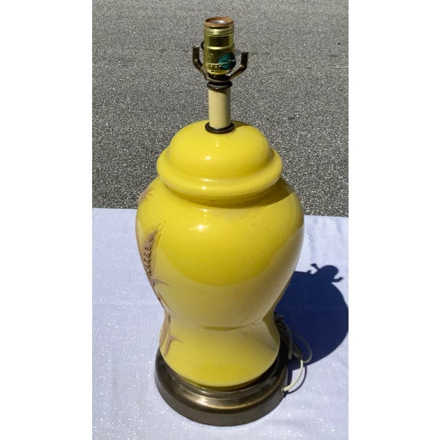 This is a Mid Century Yellow Ceramic Lamp With raised Floral Designs. This lamp is unique and and sits on a brass base....
