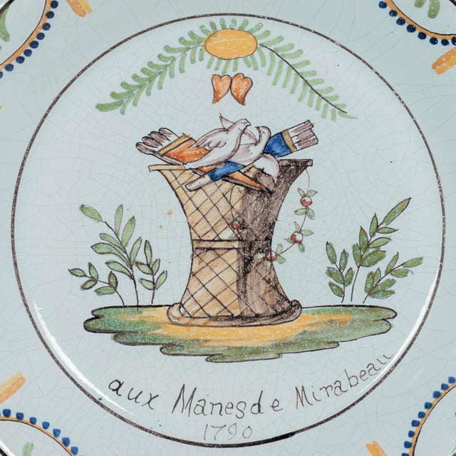 A late 18th century French faience plate entitled Aux Mans des Mirabeau 1790. Hand-painted decoration in green, orange and...