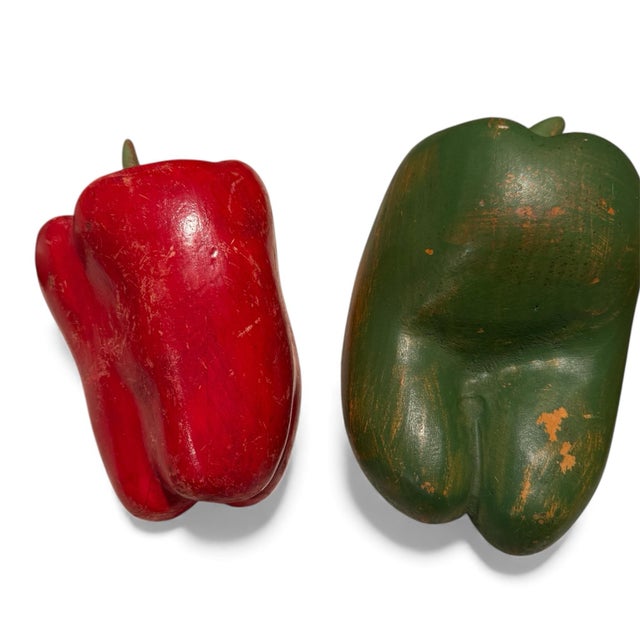 A group of carved and painted wooden vegetables and fruit. Comprising an apple, red and green peppers, and a turnip, these...