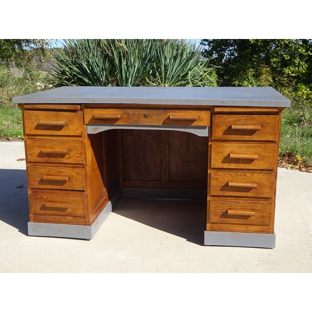 Large 9-drawer desk in oak and veneer, mid-20th century. Top: 137 x 77 cm, recently hand-patinated gray paint and finished...