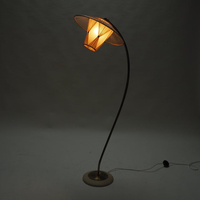 This elegant Mid-Century Modern floor lamp features a gracefully curved brass stem, creating a light, sculptural...
