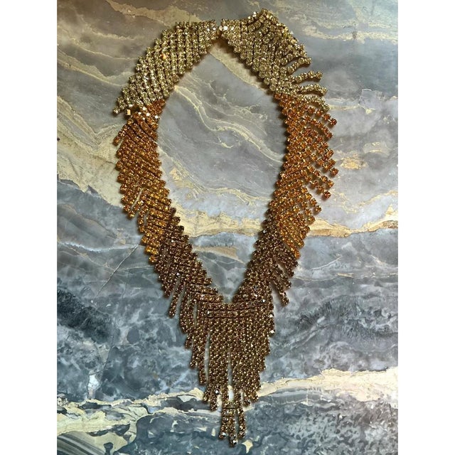 This vintage statement necklace is a dramatic cascade of rhinestone-set metal fringe, with dense rows of graduated...