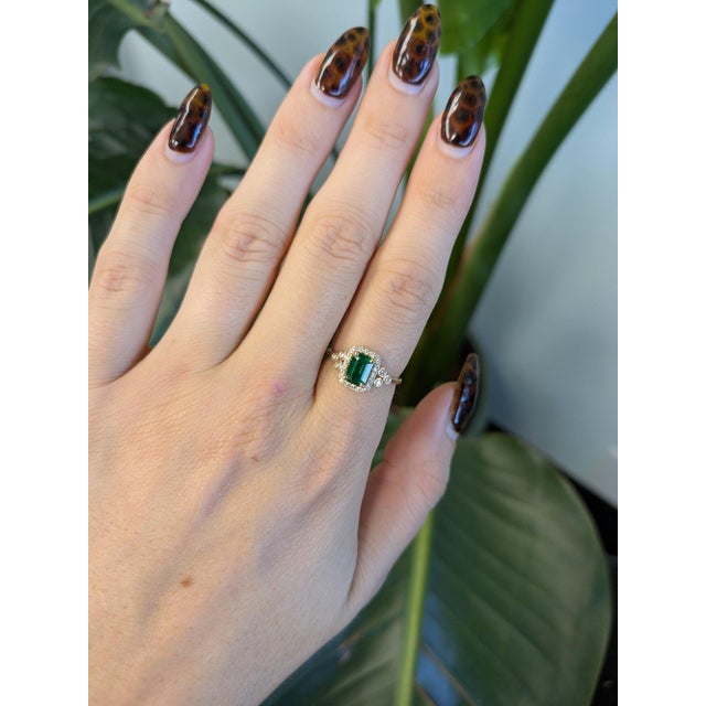 A 0.95ct zambian emerald emerald cut ring set in solid 14K yellow gold, set with twenty-six earth mined diamonds. Emerald,...