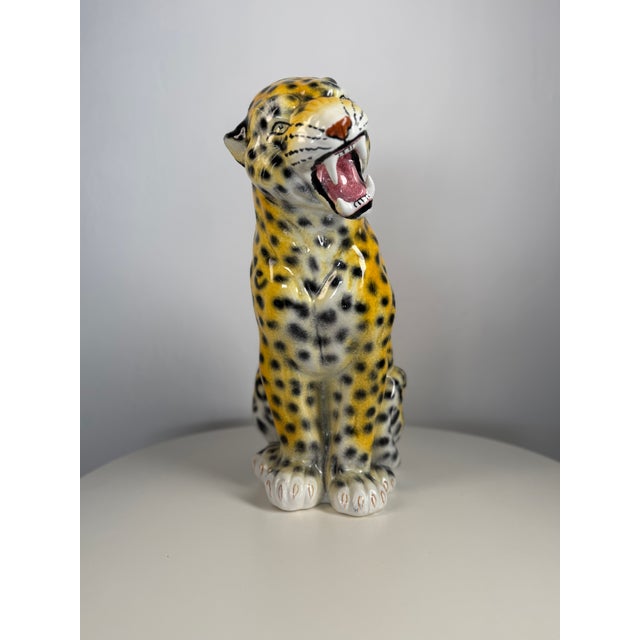 Striking set of three hand-painted Italian ceramic leopard figures, depicting a family consisting of one large adult...