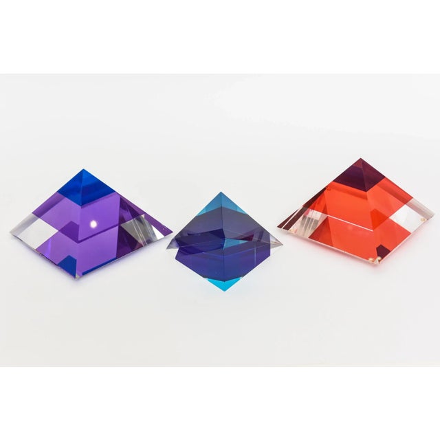 This set of 3 brilliant jewel toned lucite pyramid sculptures are a fabulous decorative object for your home. Two of them...