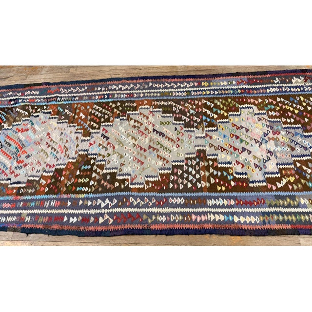this early-20th-century Turkish Village Kilim is a captivating example of Anatolian tribal textile artistry. Handwoven...