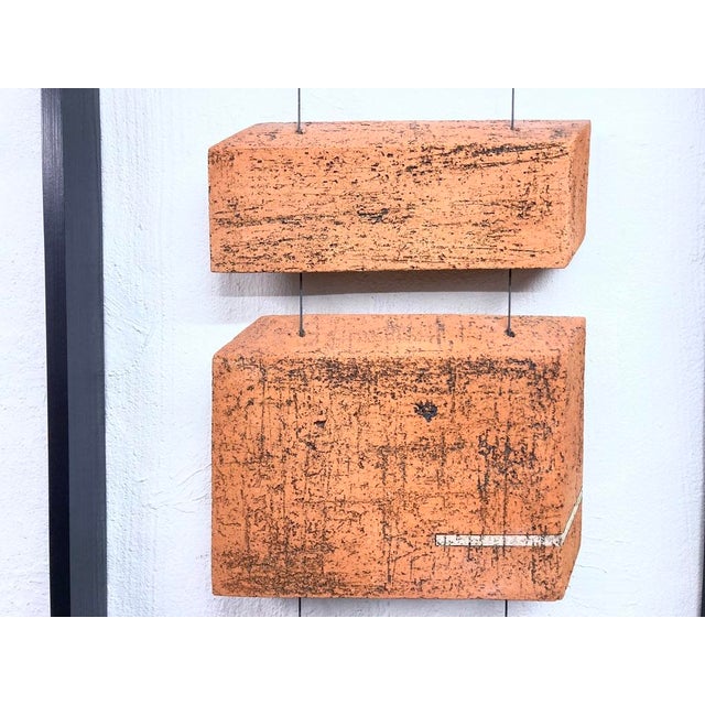 Mounted, framed wall sculpture from the 1970s to 1990s. Exact age unknown. Signed. Signature is illegible. Two terracotta-...
