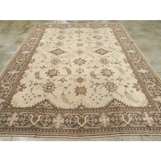An antique Turkish Oushak room size carpet. This western Turkish town piece has a spacious, genuine allover pattern repeat...
