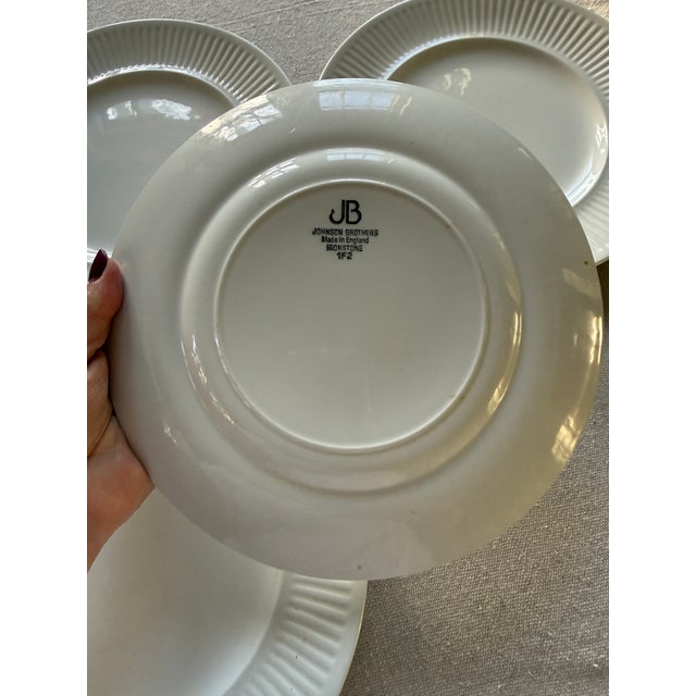 Lovely set of six plates , made in England, presented in all white with a rib, fluted design around the rim of the plate ....