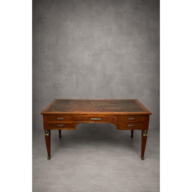 Elegant French Empire-style executive desk featuring a refined leather writing surface, five drawers, and decorative gilt-...