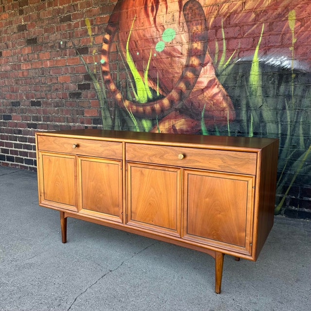 This is a Kipp Stewart for Drexel Declaration credenza. It is made from walnut and features two drawers and two cabinets...