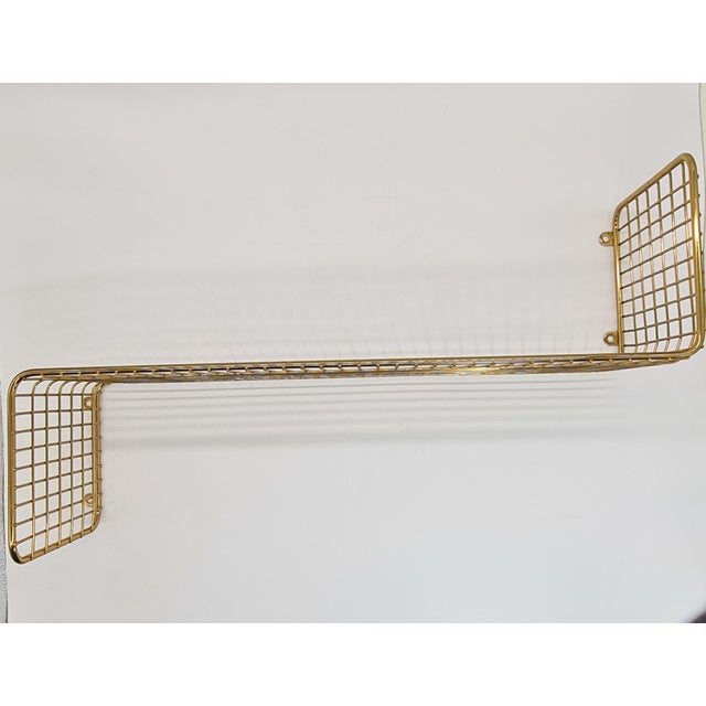 Wall shelf made of wire/mesh, finished in gold. A very interesting, visually light form, yet solid construction. It fits...