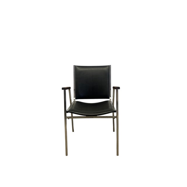 This vintage mid-century modern armchair from the 1970s features a minimalist frame constructed from tubular chrome,...