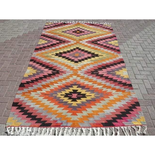 This Turkish Kilim rug hosts an intriguing pallet of vibrant rich and pastel colorways complementing a very turkish sense...