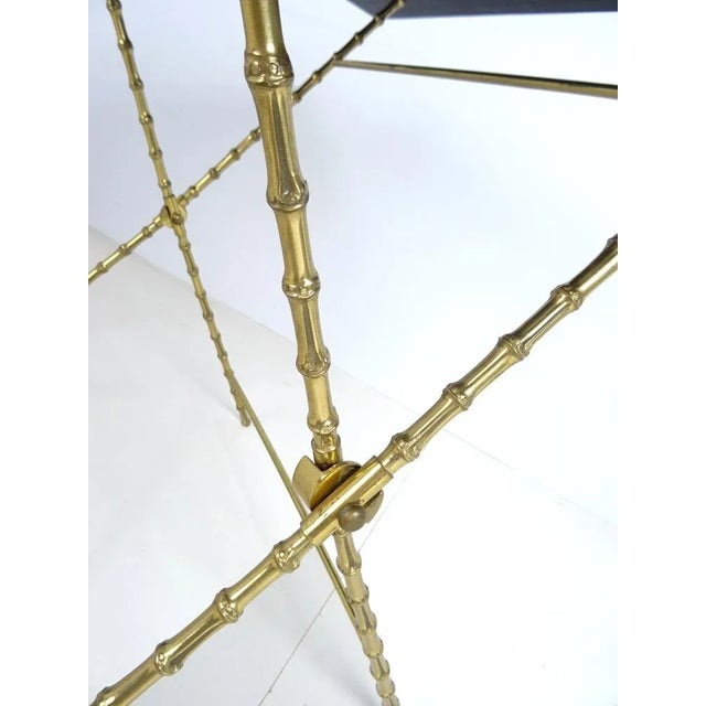 Brass frame in bamboo look with a thick black glass plate onto This piece is attributed to the mentioned designer/maker....