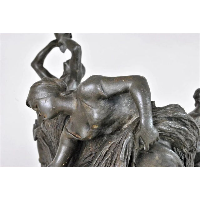 Large pewter vase with dark patina representing a man and two women during the harvest: the man is standing, drinking, one...