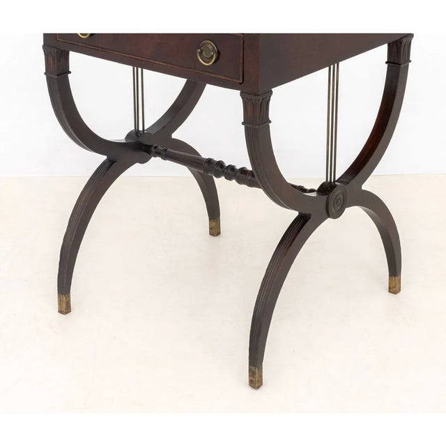 A pair of elegant English Regency side tables crafted in mahogany with inset tooled leather tops over a single frieze...