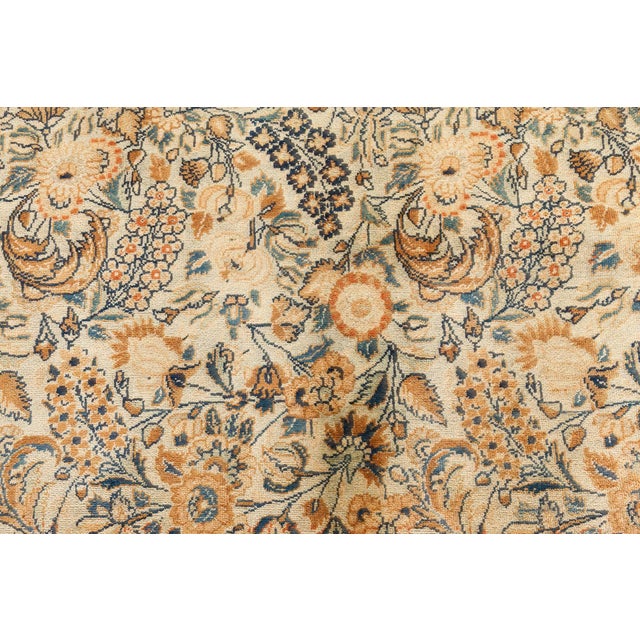 An early 20th century Persian Meshad (Meshed) antique rug, the sand field with a condensed allover pattern of blossoms and...