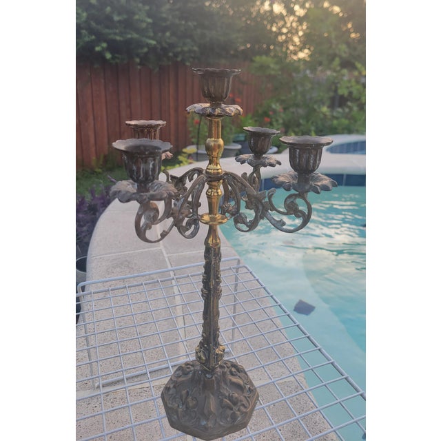 Vintage five arm ornate bronze candelabra. It features a central tall candle holder surrounded by four decorative...