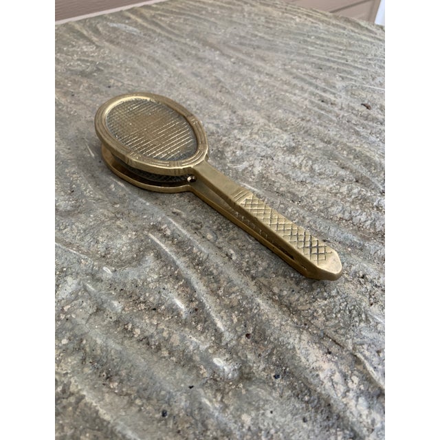 A beautiful cast brass door knocker in the form of a tennis racket. USA, Late-20th Century Measures: 2.5"W x 1.38"D x 8"H....