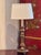 A 19th century altar stick converted as a lamp, with a turned shaft rising from a circular base set on small feet. The...