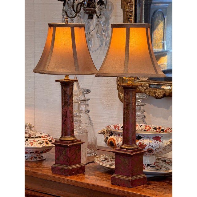 A pair of wooden column lamps. They are faux marbled.
