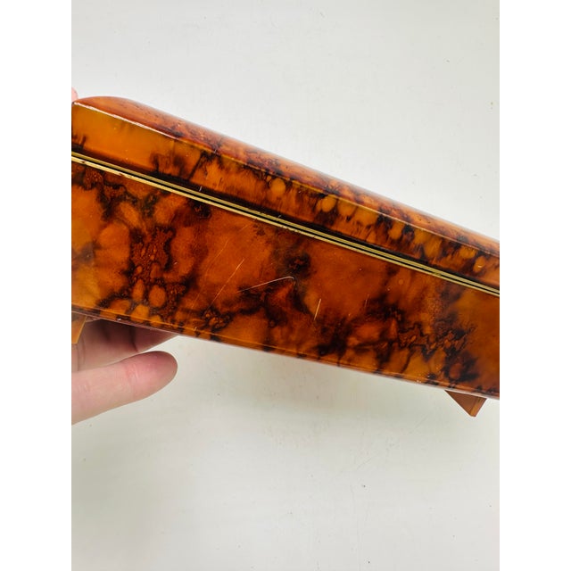 This is a vintage tortoiseshell-style jewelry box with a rectangular shape and glossy marbled amber-brown finish. The box...