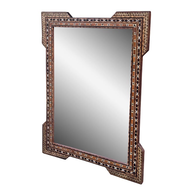 A stunning example of mid 20th-century craftsmanship, this mirror features natural wood inlaid with delicate mother-of-...