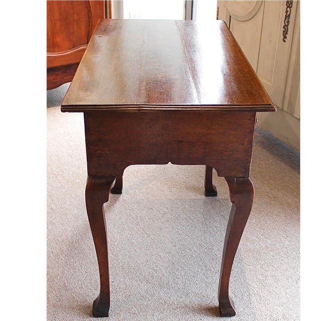 A diminutive and somewhat rustic George II English country lowboy, ca. 1750, resting on squared pad-footed cabriole legs...