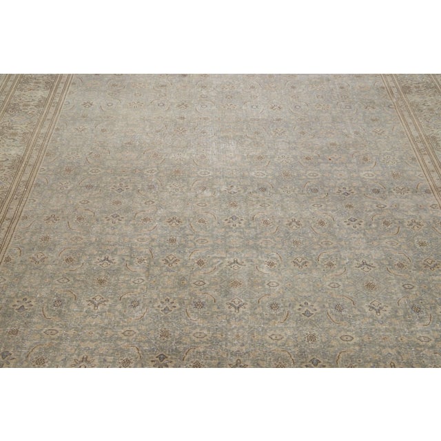 Beautiful hand-knotted antique Agra wool rug with a gray color field. This Persian rug has brown and blue accent colors in...