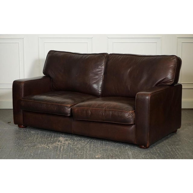 Vintage Distressed Brown Leather Two to Three Seater Sofa. It has a classic and elegant design with a worn-in look that...